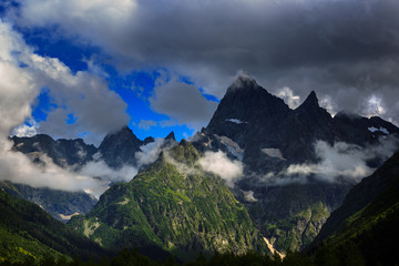 Peak of the mountain with glaciers against the background of clouds and sky. Caucasian ridge,...