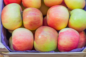 top view of red ripe apples in a wooden box at the farmer's market