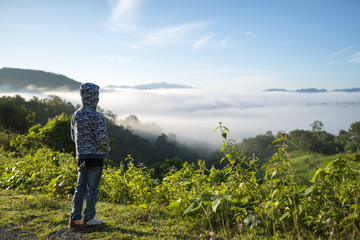Young boy traveler looking sea of mist