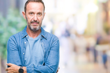 Middle age hoary senior man over isolated background with serious expression on face. Simple and...