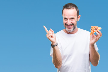 Middle age hoary senior man eating pizza slice over isolated background very happy pointing with hand and finger to the side