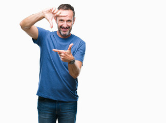 Fototapeta premium Middle age hoary senior man over isolated background smiling making frame with hands and fingers with happy face. Creativity and photography concept.