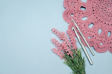 .pink openwork cloth, tied with hooks, lies on a blue background