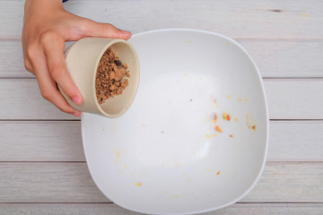 Pouring brown sugar into mixing bowl with ingredients for making cookies