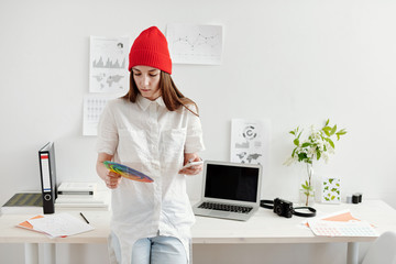 Freelance designer using color wheel and gadgets for work