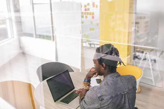 Young african businessman typing email in modern office