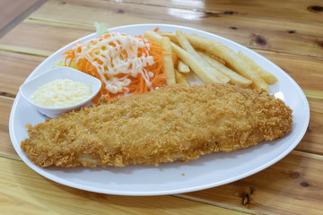 Fish steak with french fries and salad.