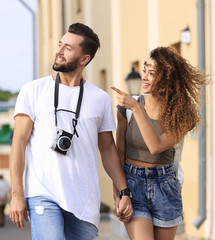 Naklejka premium A loving couple of tourists look at each other and walking