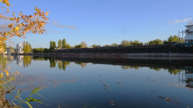 4K. process of boat barges for the carriage of goods in the lock of the Volga-Don ship canal. Ships, water, yellow autumn leaves, beautiful reflection