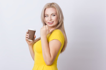 Blonde woman holding coffee cup in her hands