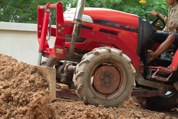 Worker driving the tractor for grading the level of ground