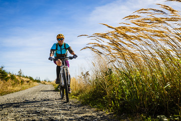 Cycling, mountain bikeing woman on cycle trail in autumn forest. Mountain biking in autumn...