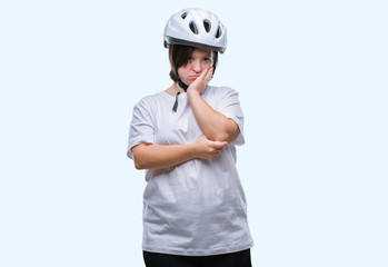 Young adult cyclist woman with down syndrome wearing safety helmet over isolated background thinking looking tired and bored with depression problems with crossed arms.