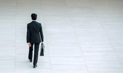 rear view from afar.a businessman with a leather briefcase
