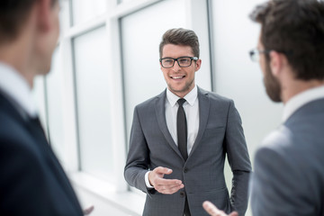 boss talking to employees standing in the office