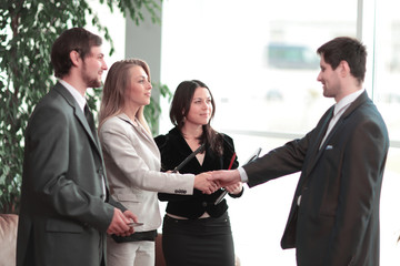 close up. handshake business woman with businessman in modern business center
