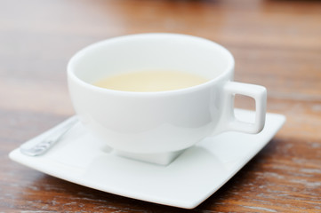 White cup of tea on wooden table. Tea drinking