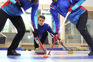 Fototapeta Mecz curlingowy. Młodzi ludzie na lodowisku. obraz
