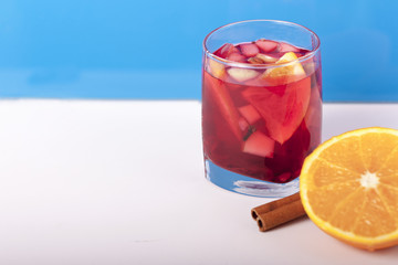 Бокал с глинтвейном и апельсином на синем фоне 