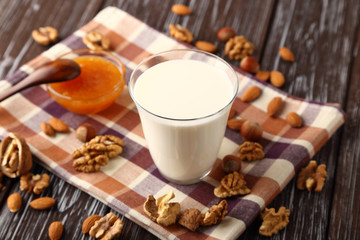 A glass of fresh milk with almonds, hazelnuts, walnuts and honey.