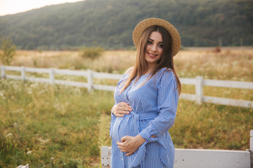 Clode up view of beautiful pregnant lady in knitted hat. Lady smile to camera