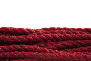 One skein of jute rope six millimeters for Japanese bondage and shibari, painted in red on a white...