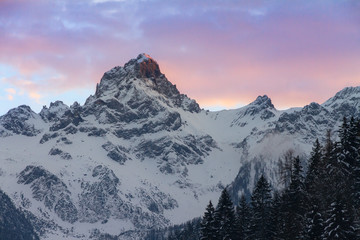 Fototapeta na wymiar Beautiful evening sunset view of mountain tops with snow and vibrant clouds in the Brandnertal in the Alps in Vorarlberg, Austria, in winter