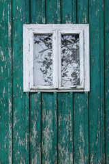Naklejka na ściany i meble Old window on a wooden farm house wall