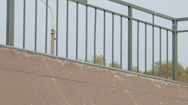 Skater make beautiful spin trick on the edge of wooden mini ramp, slowmotion