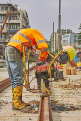 Construction worker welding iron train tracks.