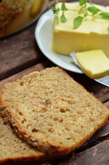 Sliced rye bread on sourdough on a wooden background. Butter on a plate on a wooden background