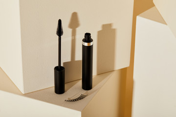 close-up shot of false eyelash and mascara on beige