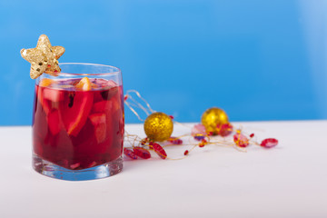 Стакан с глинтвейном, украшенный золотой звездой и новогодней мишурой 