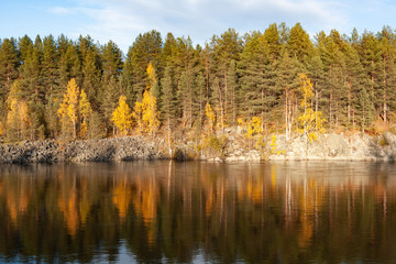 Typical autumn landscape, colorful trees reflected in the lake