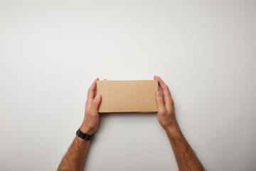 cropped image of man holding delivery food box on white surface