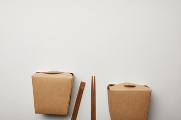 top view of arranged chopsticks and noodle boxes on white surface, minimalistic concept