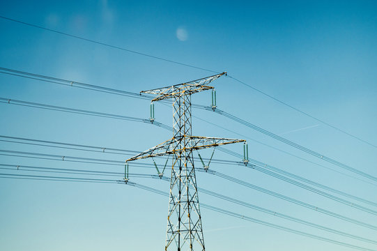 Three-phase electric power transmission line against blue sky