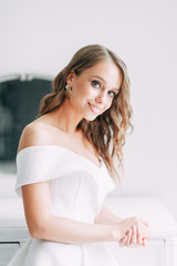 Naklejka premium A concept wedding, contemporary European bride. Bouquet of flowers, fees in the interior Studio. Ideas for a minimalist wedding, white color