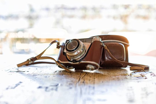 Analoge Kamera aus den 60th mit Schutzh&uuml;lle und Riemen auf Tischplatte mit Gravur 