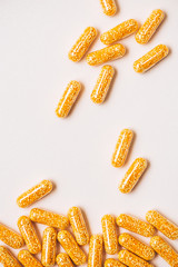 top view of yellow medical capsules on white