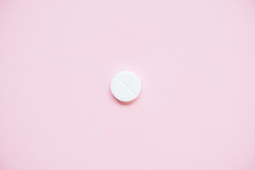 top view of white medical pill on pink surface