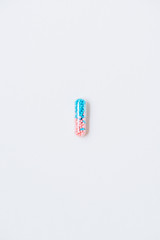 top view of pink and blue medical capsule on white
