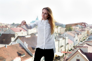 Fototapeta na wymiar Young attractive stylish woman in white shirt and black trousers in the open air place
