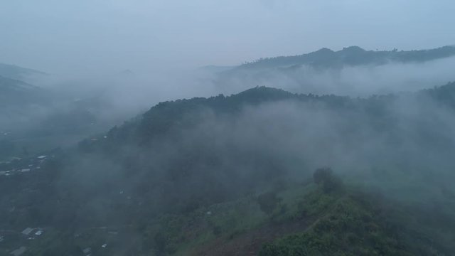 Aerial drone view of Chiang Rai beautiful mountain fields landscape during foggy morning, Thailand