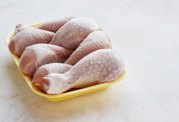 fresh raw chicken pieces on a light background in a tray