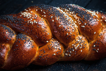 Fresh homemade bun with poppy seeds, with ingridients on dark rustik background. Copy space for text, brand or logo. Concept photo of low key bakery. Close up and top view
