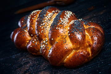 Fresh homemade bun with poppy seeds, with ingridients on dark rustik background. Copy space for text, brand or logo. Concept photo of low key bakery. Close up and top view