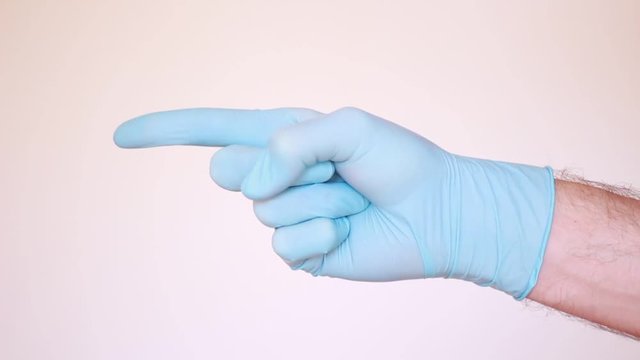 Doctor's forefinger in blue glove pointing