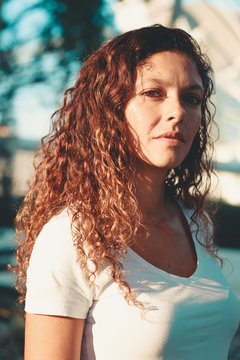 portrait of happy woman with urban style and curly hair