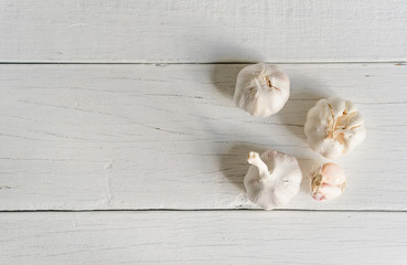 Organic garlic whole and cloves on wooden background.
